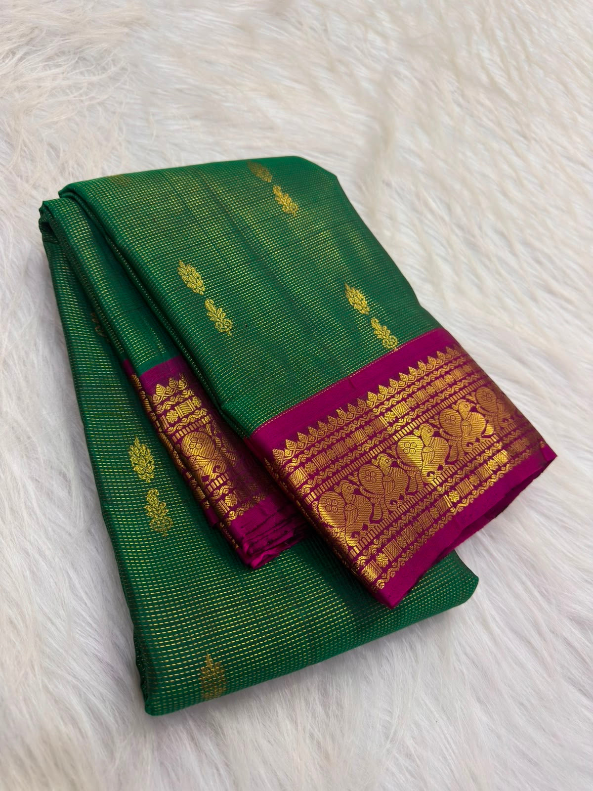 Raspberry-pink peacock border detail, emerald-green KanchiPattu saree