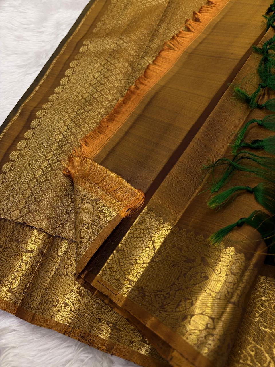 Emerald green Kanjeevaram silk saree with traditional gold zari close-up