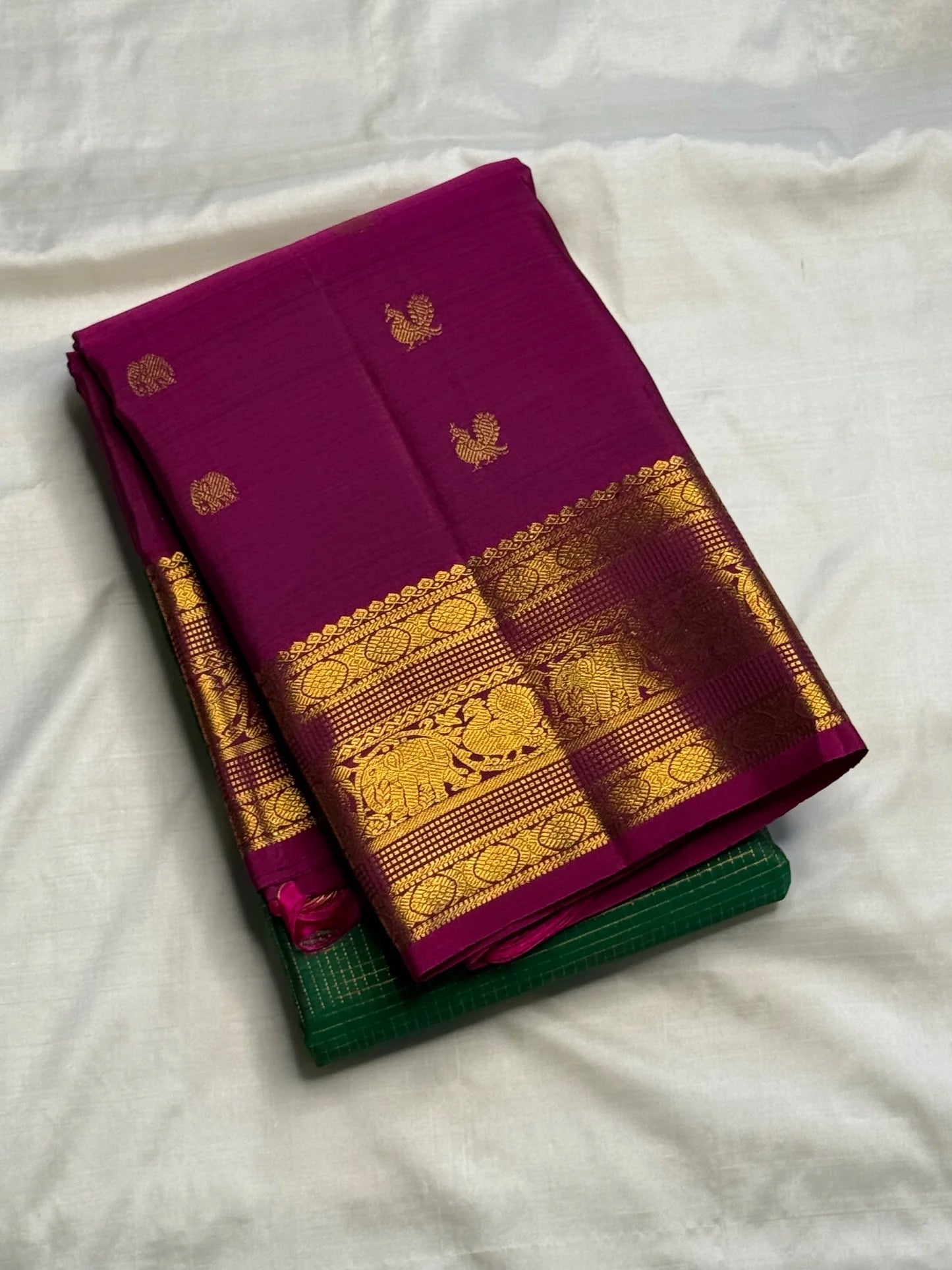 Radiant green Kanchipuram silk saree with alternating Yaanai and Chakram gold zari buttas.