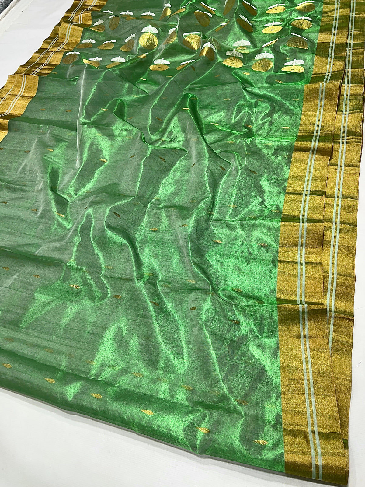 Small gold-toned motifs on jade green tissue silk