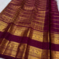 Lac-maroon Kanchipuram silk body with fine classic-gold Zari Kattam geometry and traditional zari buttas.