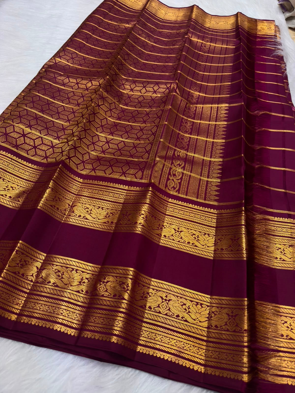 Lac-maroon Kanchipuram silk body with fine classic-gold Zari Kattam geometry and traditional zari buttas.