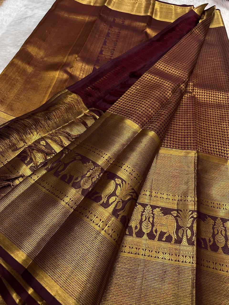 Exclusive Zari Kattam Kanjivaram saree with dense antique-gold weaving and elephant motifs.