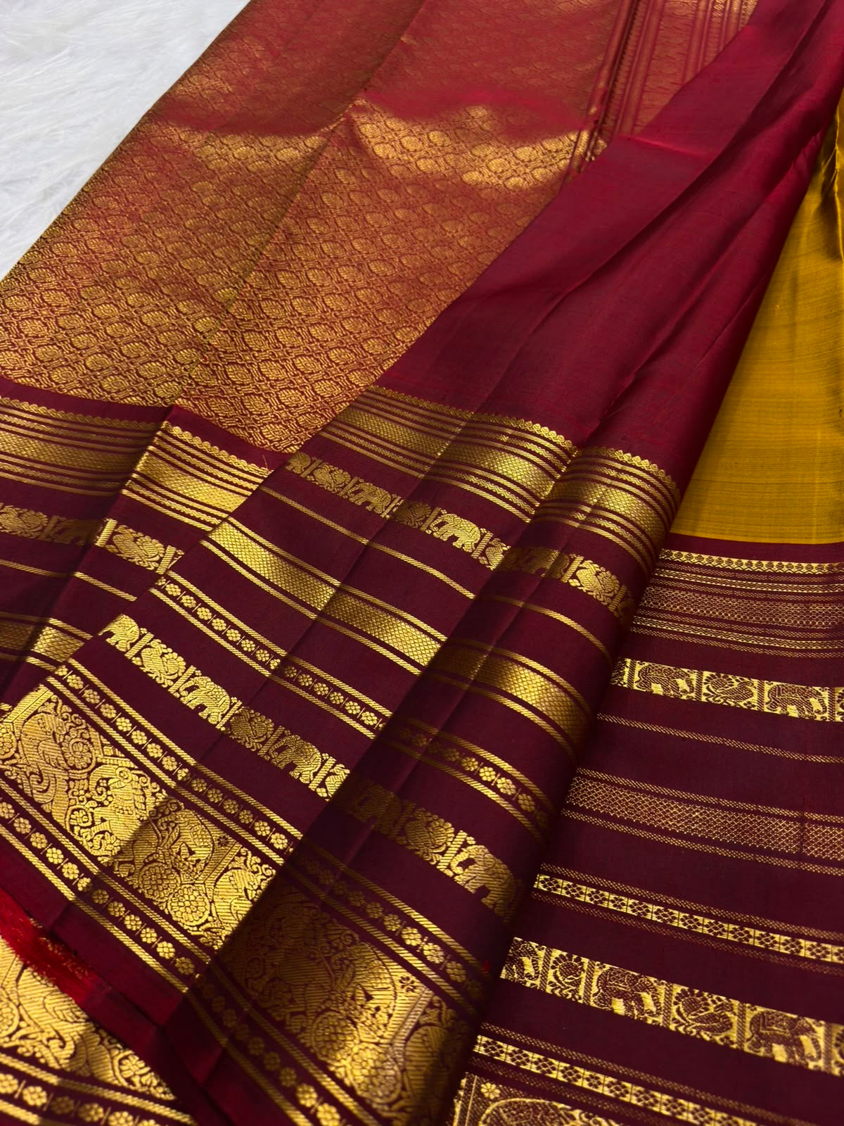 Detailed view of traditional Yaanai motifs arranged between horizontal gold zari bands on an Arakku border.