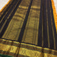 Turmeric yellow Kanchi Pattu saree folded with black and gold Kai Korvai border, lotus zari pallu and turmeric tassels.