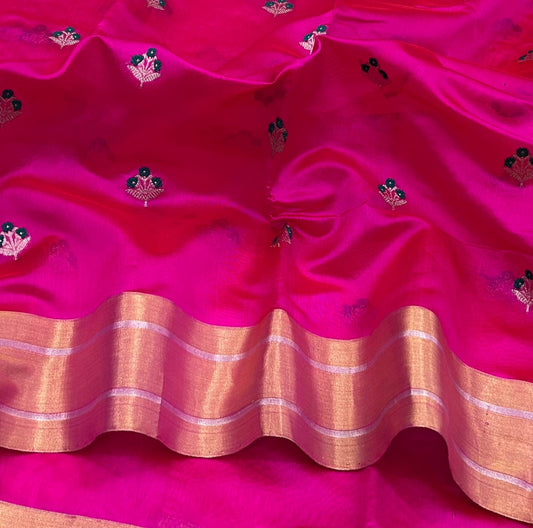 Close view of the rani pink Chanderi body with small gold-toned and green floral buttas