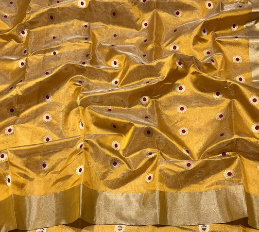 Spread view of yellow silk saree with narrow metallic edge visible