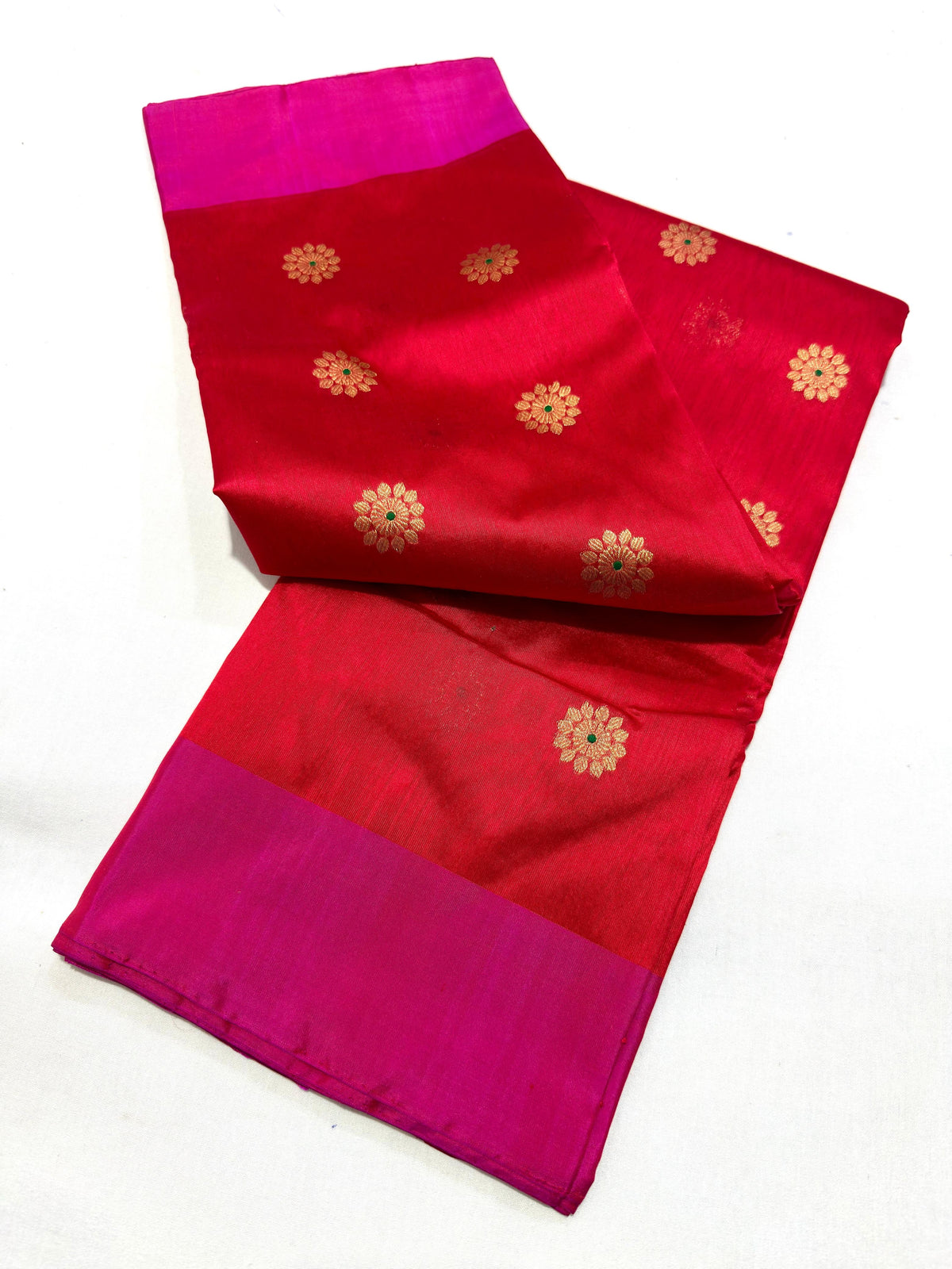 Small gold-toned flowers woven across the ruby red body of a Pattu Silk Chanderi saree.