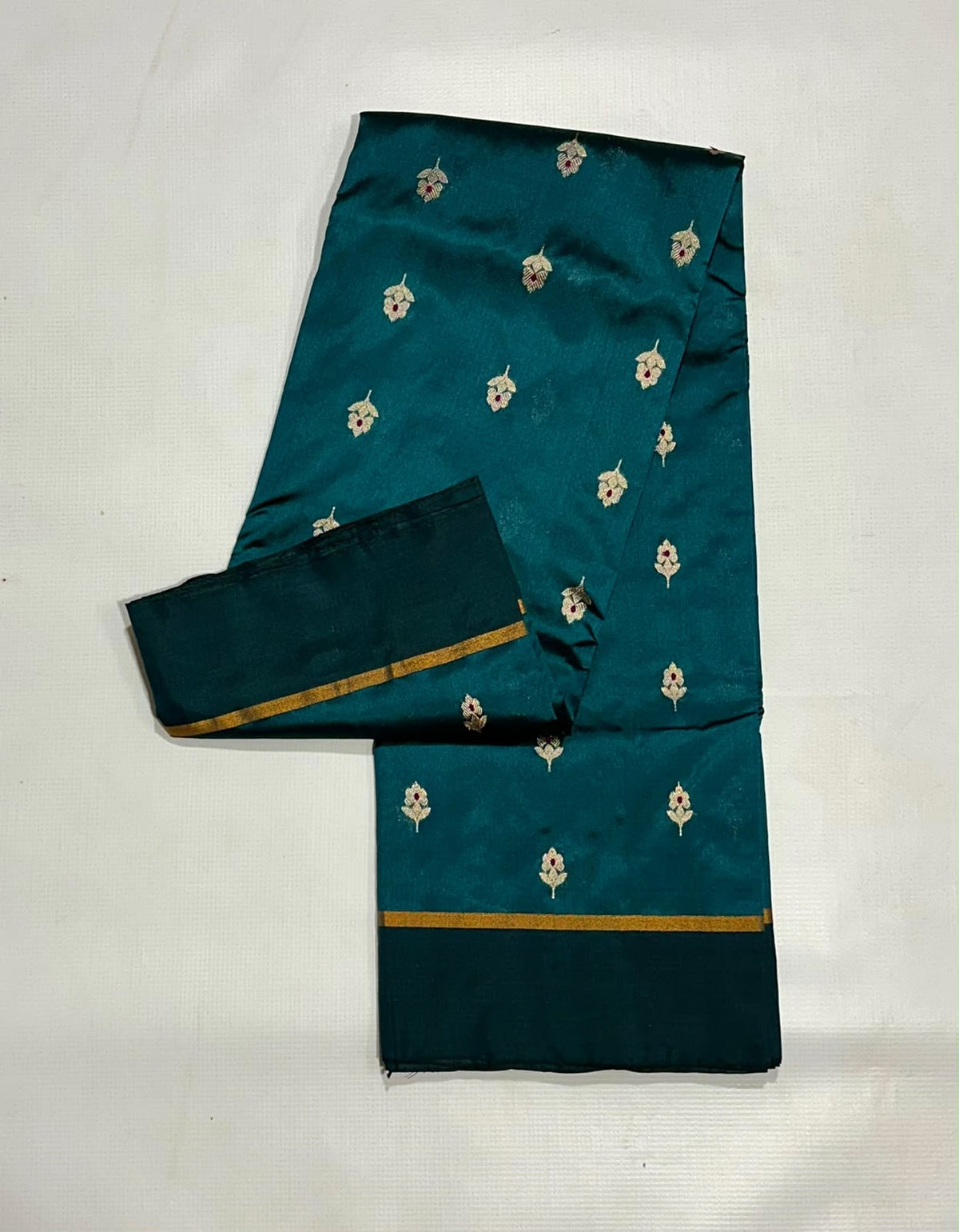 Close detail of floral buttas on a peacock teal Pattu Silk Chanderi saree.