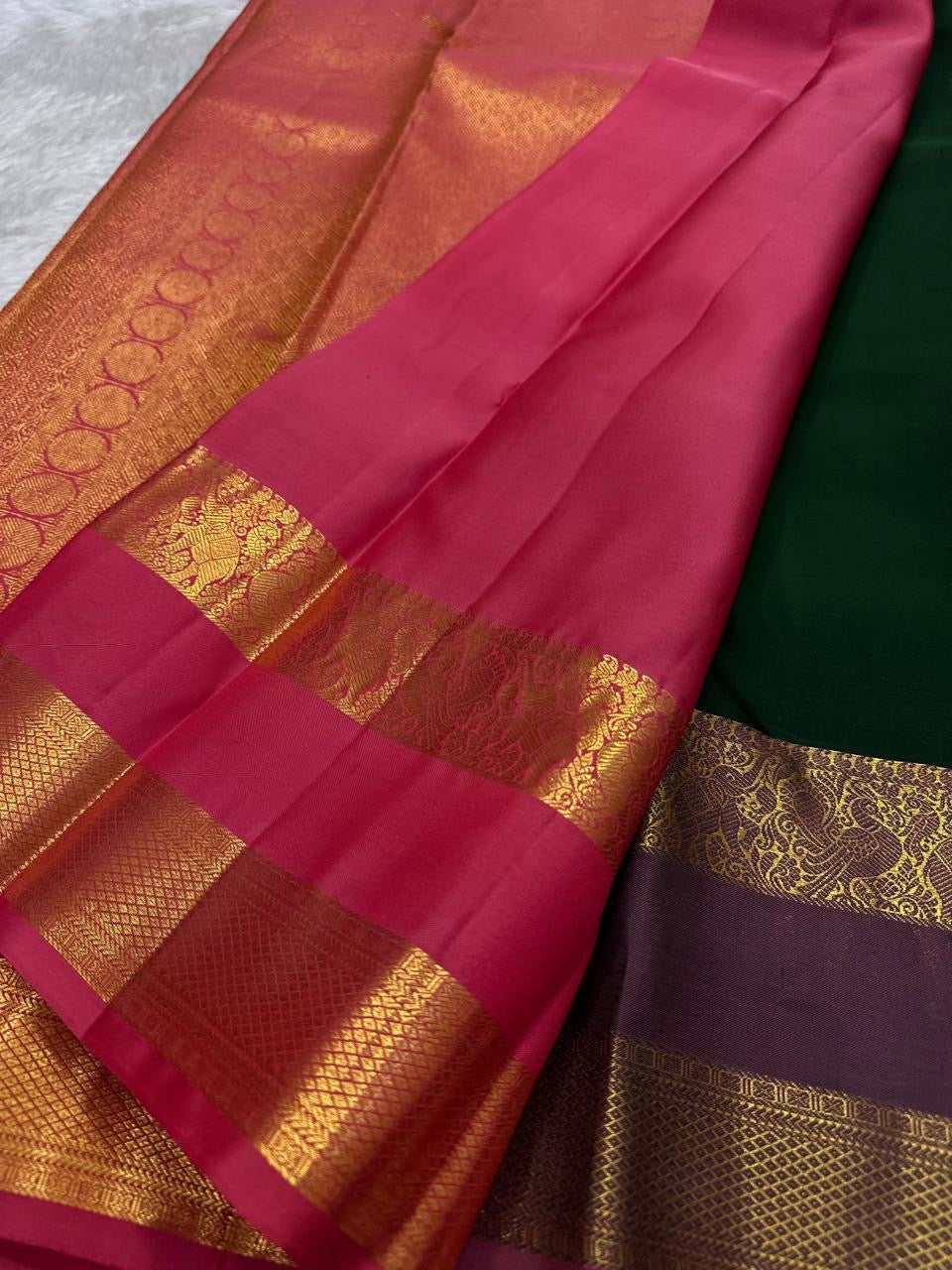 Close detail of flowering kodi-style gold zari creepers and paisley-like forms across dark green silk.