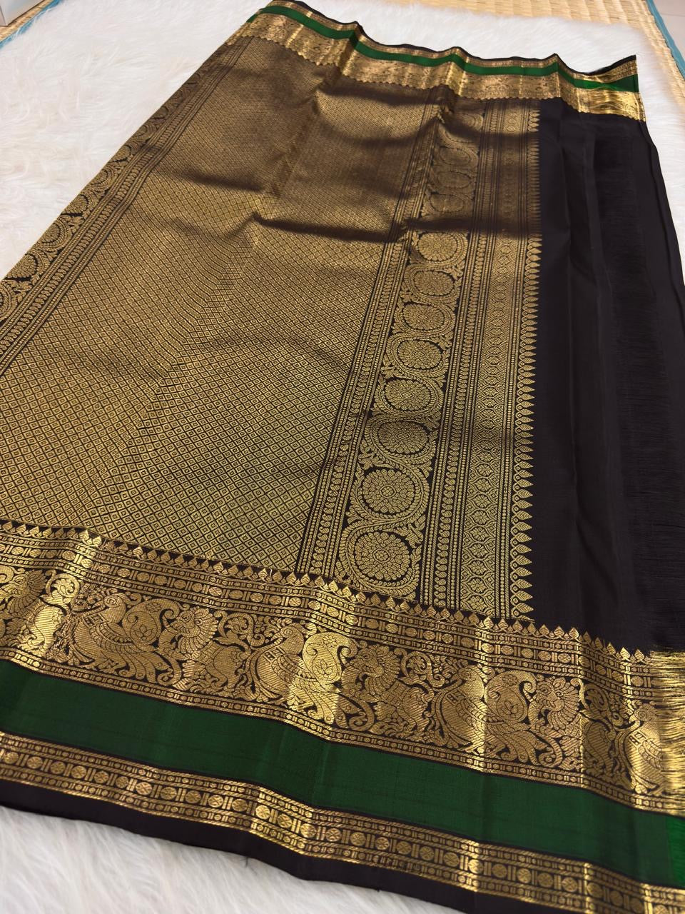 Black and emerald-green border with a broad gold peacock zari register