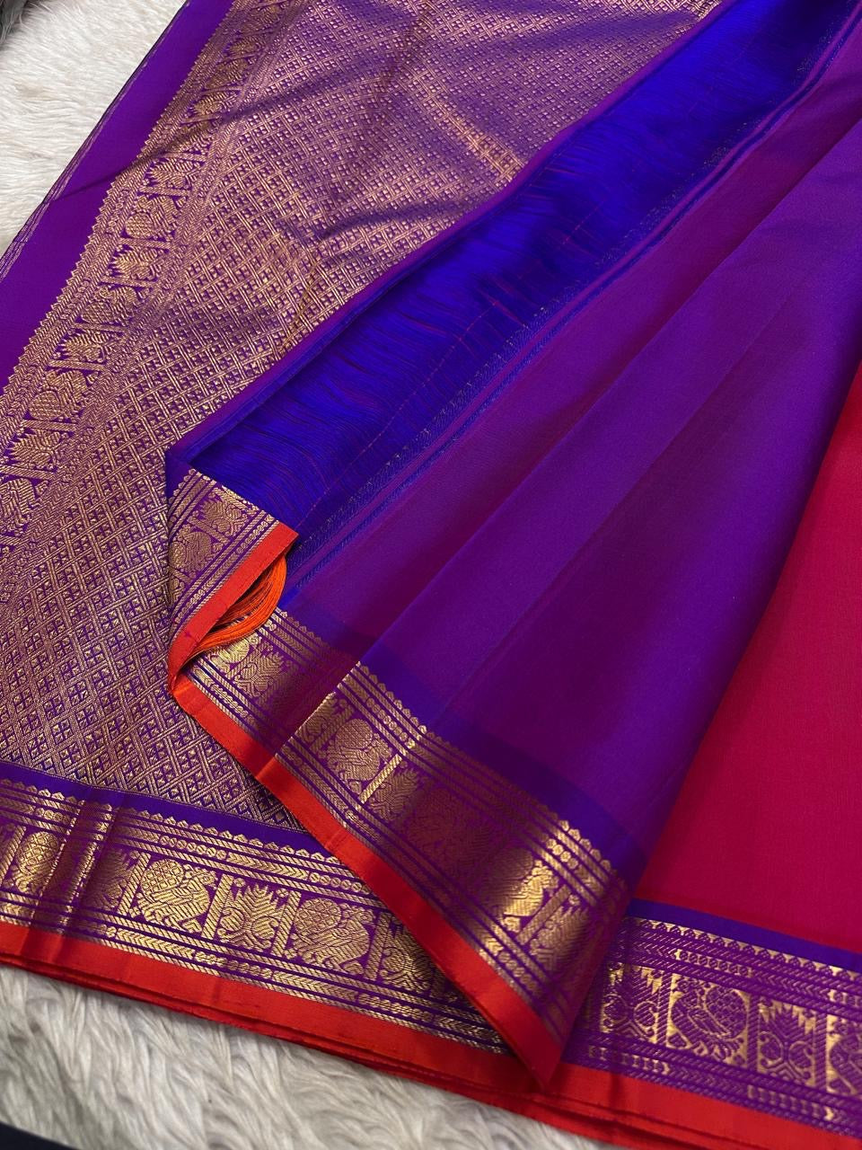 Close view of royal blue pallu with gold zari woven pattern and matching blue border with gold zari detailing.