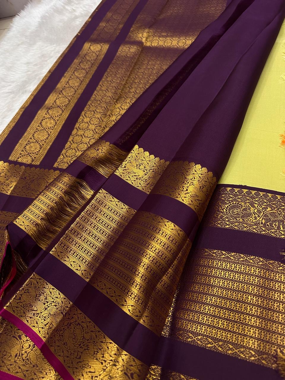 Lime chartreuse Kanjipuram silk saree body close-up showing Kudhirai flying horse antique gold zari butta motifs on plain silk ground