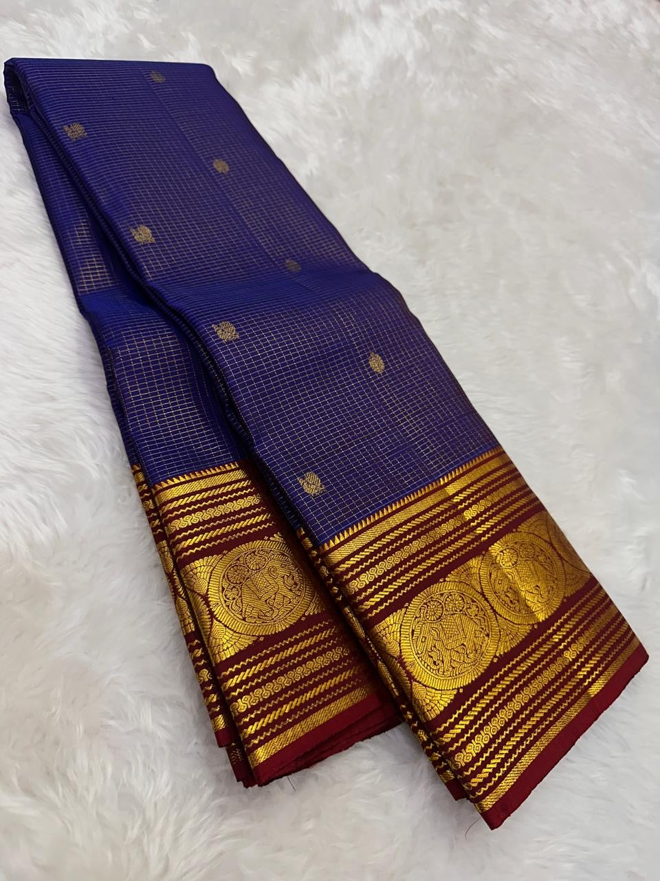 royal blue kanchipuram silk saree showing zari checks and small gold buttas