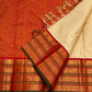 Flat-lay of red zari woven border with circular motifs and green edge on an ivory pure Kanchipuram silk saree.
