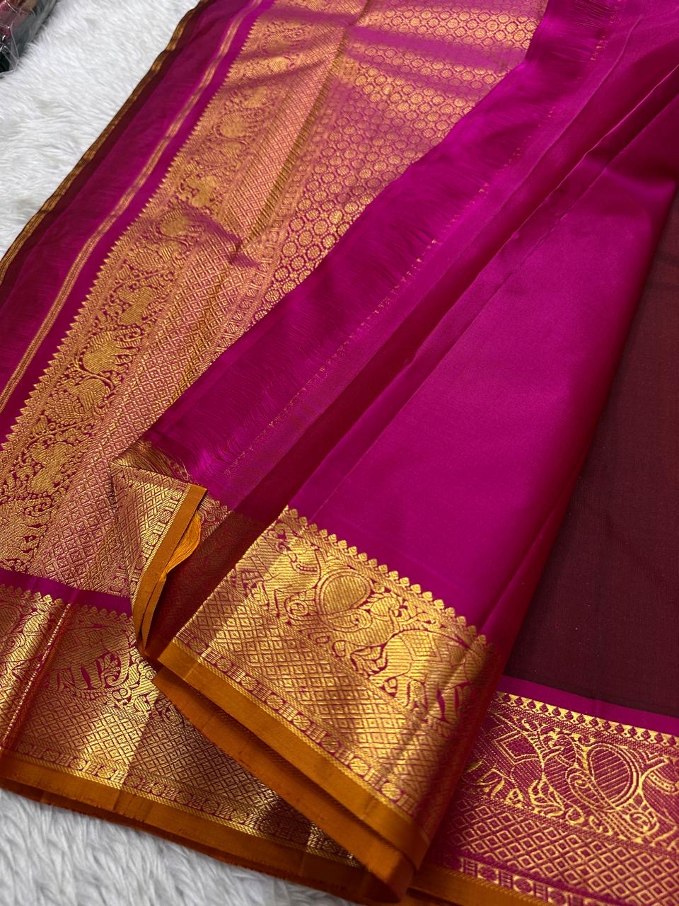 Close view of magenta silk pallu with gold zari woven pattern and matching zari woven border.