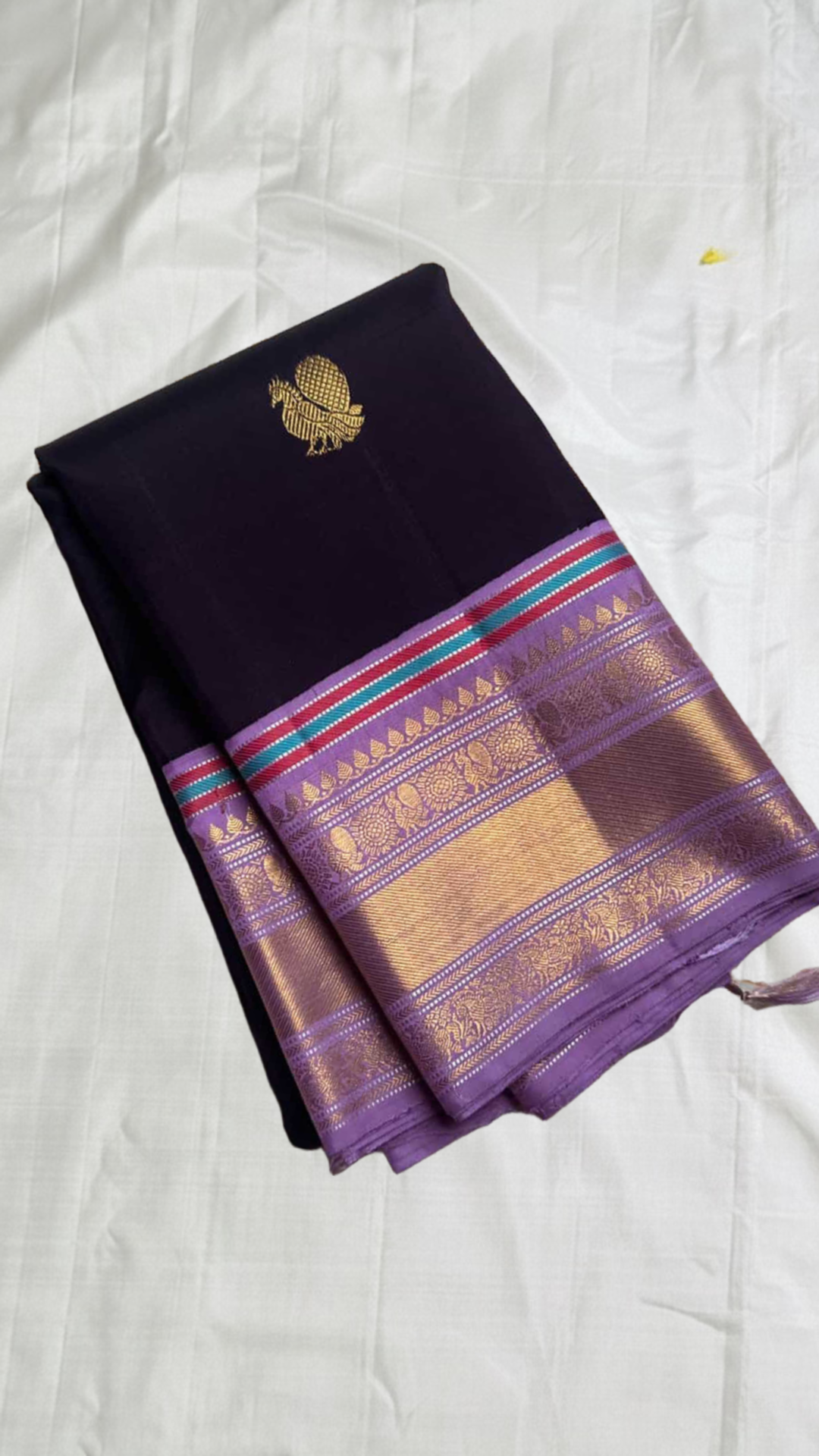 folded aubergine purple pure kanchipuram silk saree with gold zari woven butta and lavender border