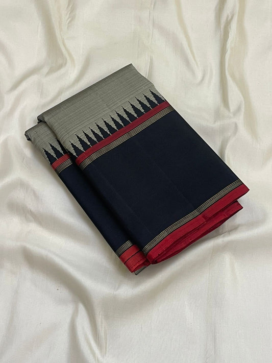 Folded grey Pure Kanchipuram silk saree with black border, red selvedge, and pillayar reku motif along the edge.