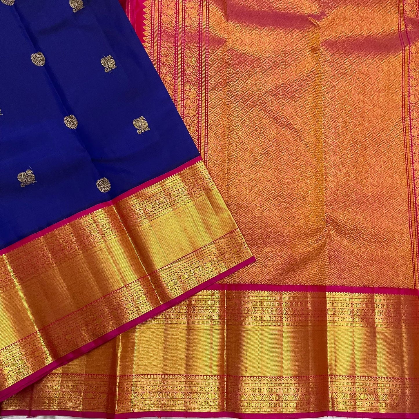 Blue Kanchipuram silk saree flat lay with gold zari pallu pattern and wide gold zari border, shipped from New Jersey USA.
