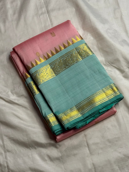 pink kanchipuram silk saree folded with sea green zari woven border