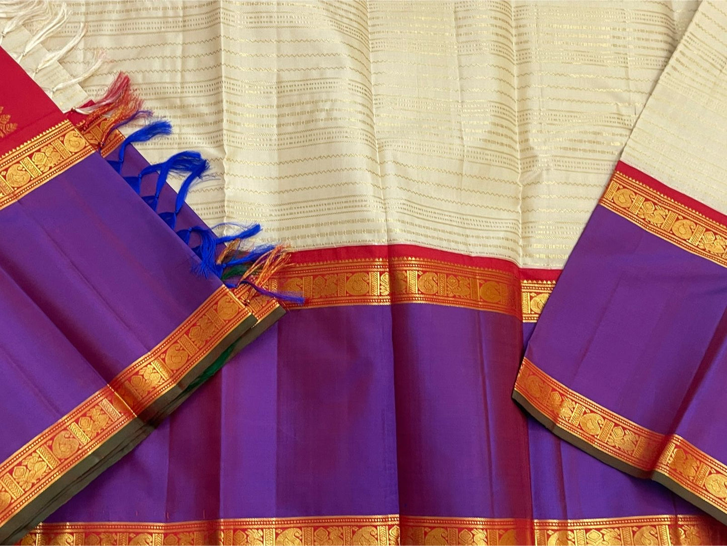 Pure Kanchipuram silk saree folded on orange zari woven pallu with blue tassels, shipped from New Jersey USA

