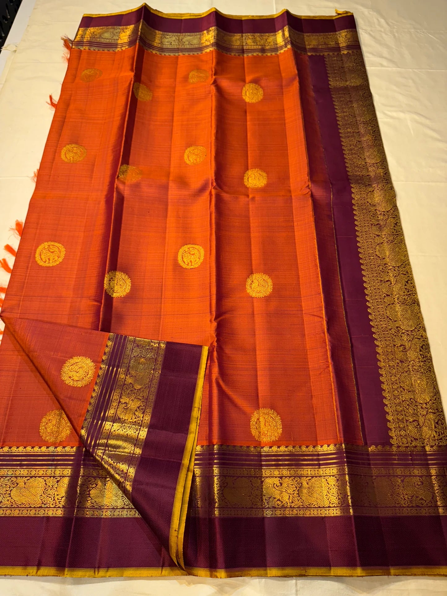 Pallu closeup of Pure Kanchipuram silk saree in deep purple with dense gold zari woven pattern and contrast border
