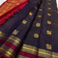 Deep plum purple Pure Kanchipuram silk saree folded lengthwise showing gold zari woven motifs and maroon zari woven border on white backdrop