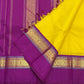 Folded yellow and purple pure Kanchipuram silk saree on purple pallu with zari stripes and tassels