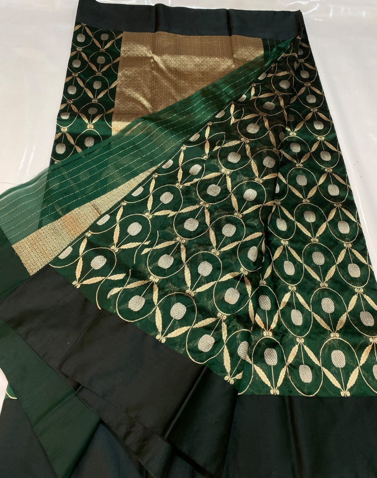 Intricate gold-toned vine and leaf lattice on green silk