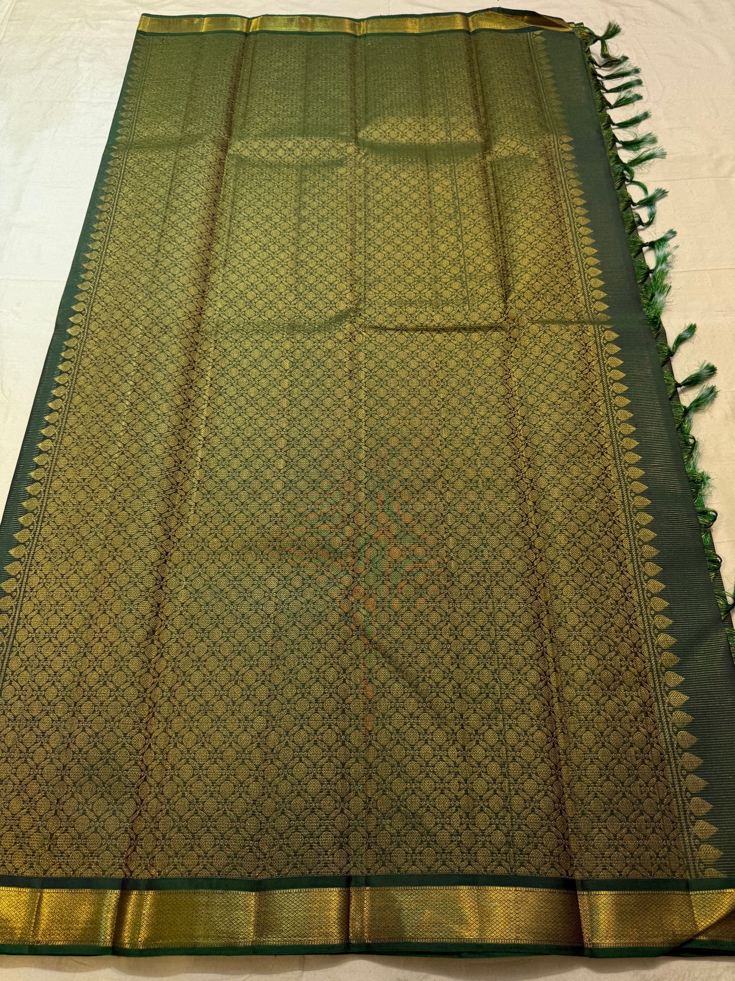 Close view of fine continuous Vairaoosi zari lines on Deep Forest Green silk.