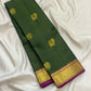 Broad gold zari border with magenta accent on forest-green Kanjivaram silk