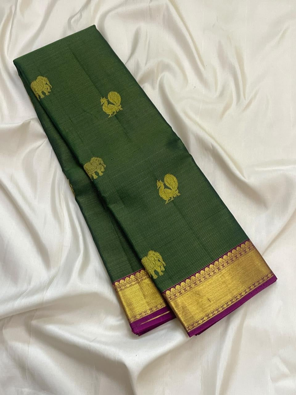 Broad gold zari border with magenta accent on forest-green Kanjivaram silk