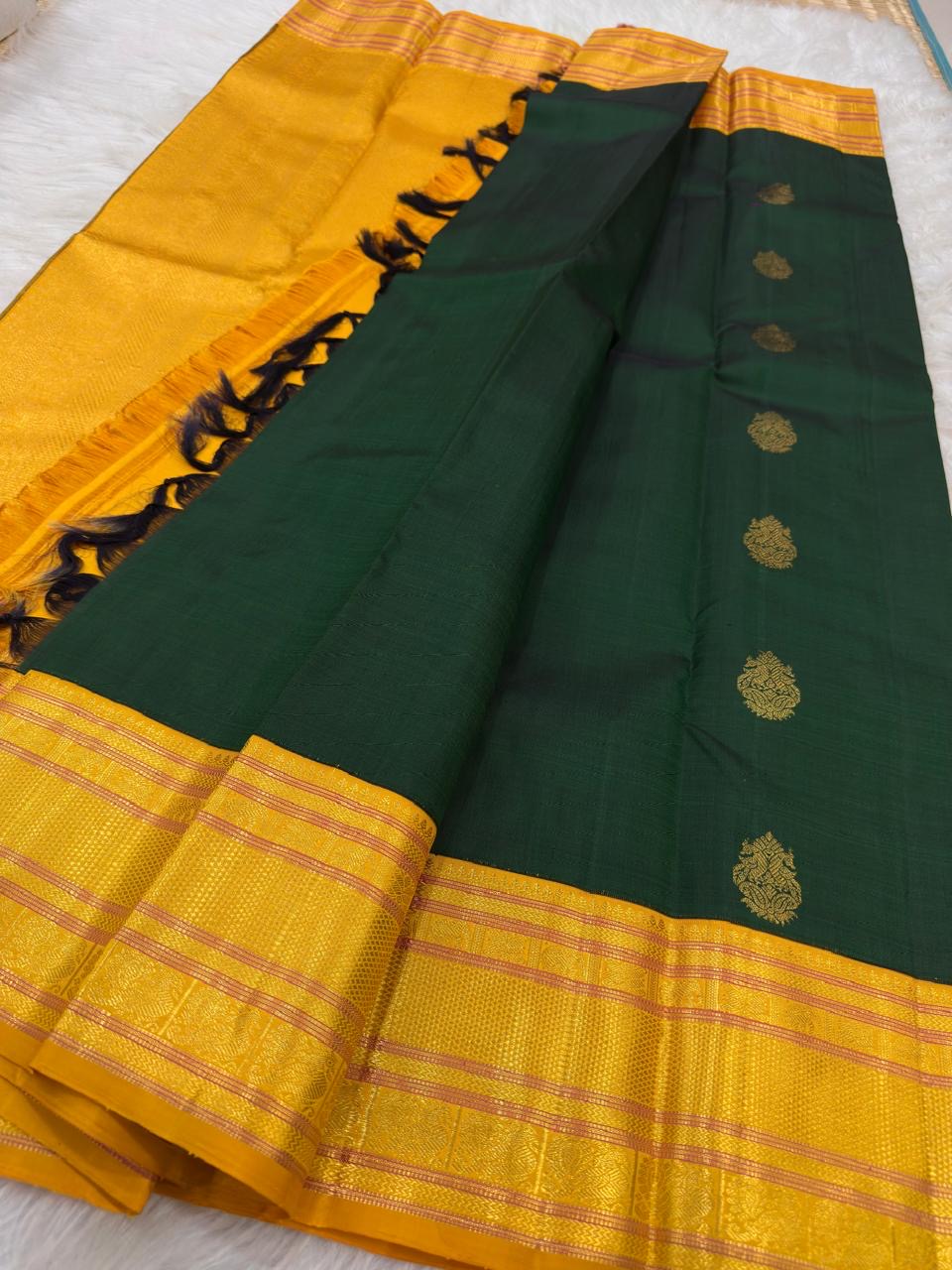 Deep forest-green pure silk body with spaced decorative zari buttas