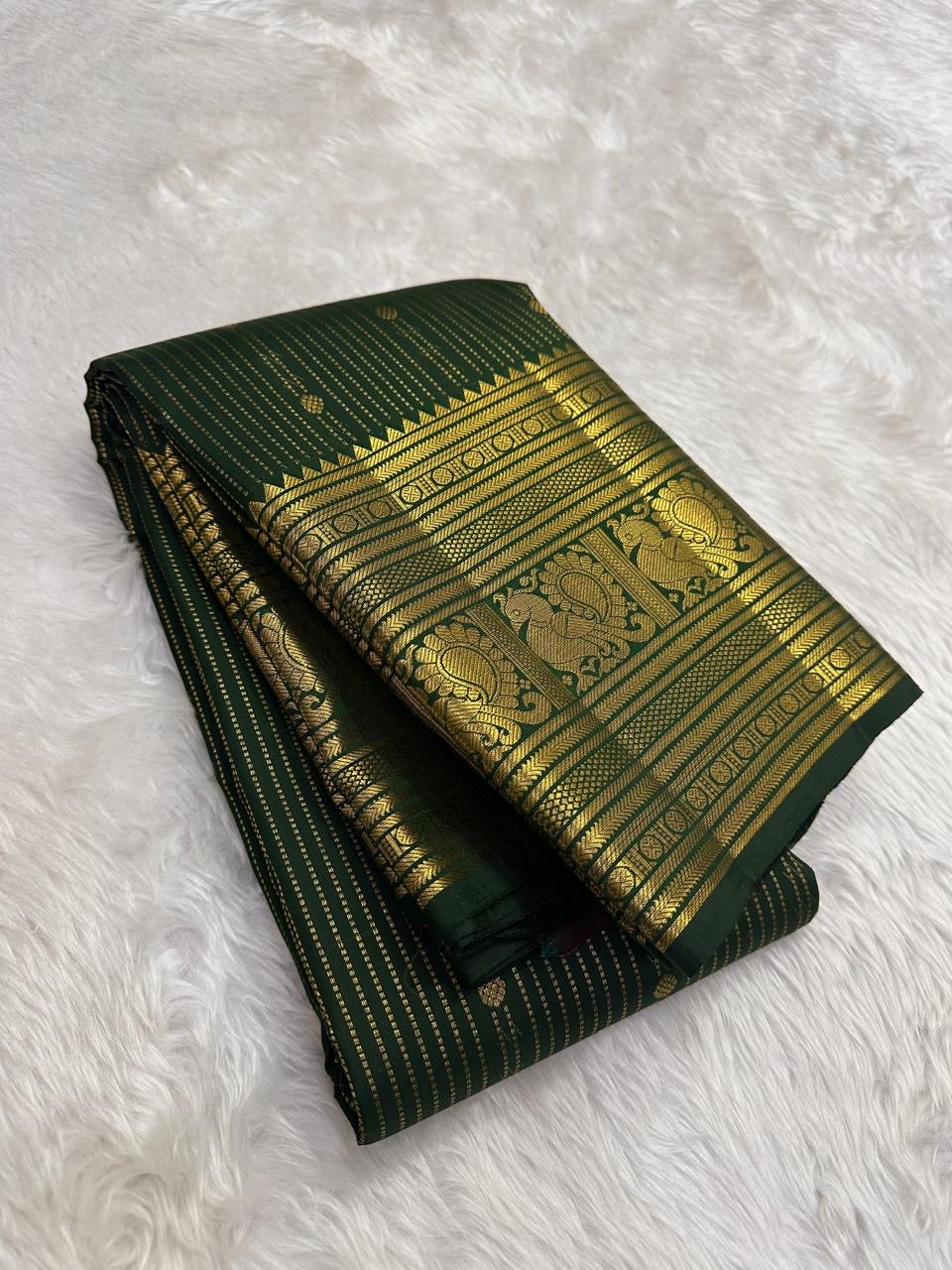 Forest Green Kanjivaram silk saree with fine vertical zari lines and petite gold buttas