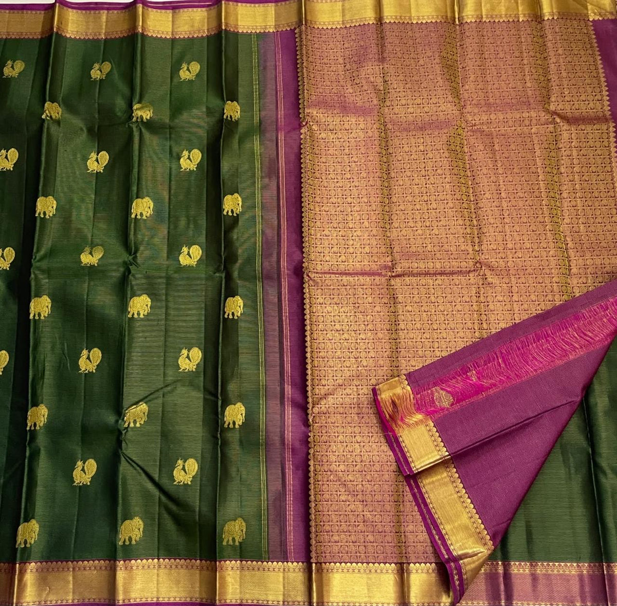 Magenta-plum contrast meeting broad gold zari border on green Kanjivaram