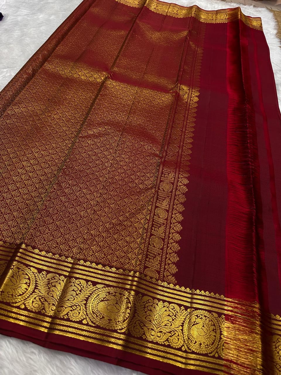 Close Arakku border detail with intricate classic-gold floral scrollwork on Kanchipuram silk.