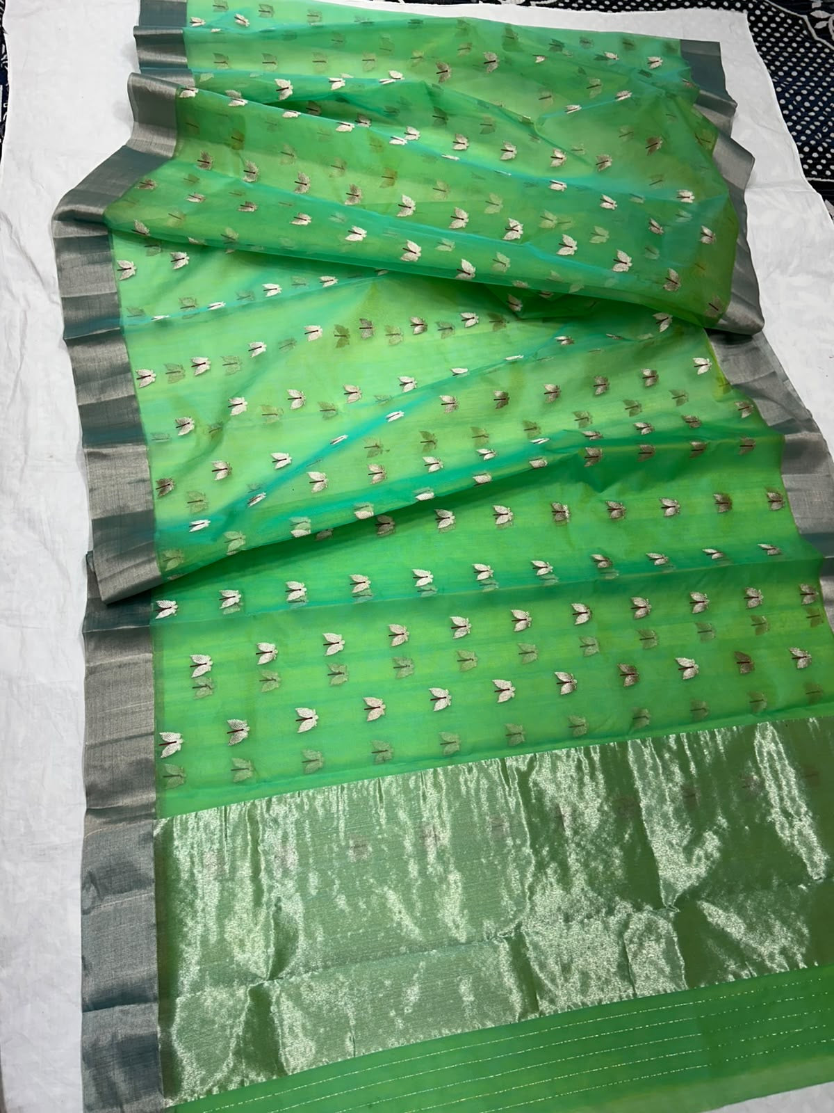 Repeating silver buttas on green Chanderi