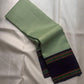 Fresh green handwoven Pure Silk Kanchipuram saree folded to show the deep contrast border