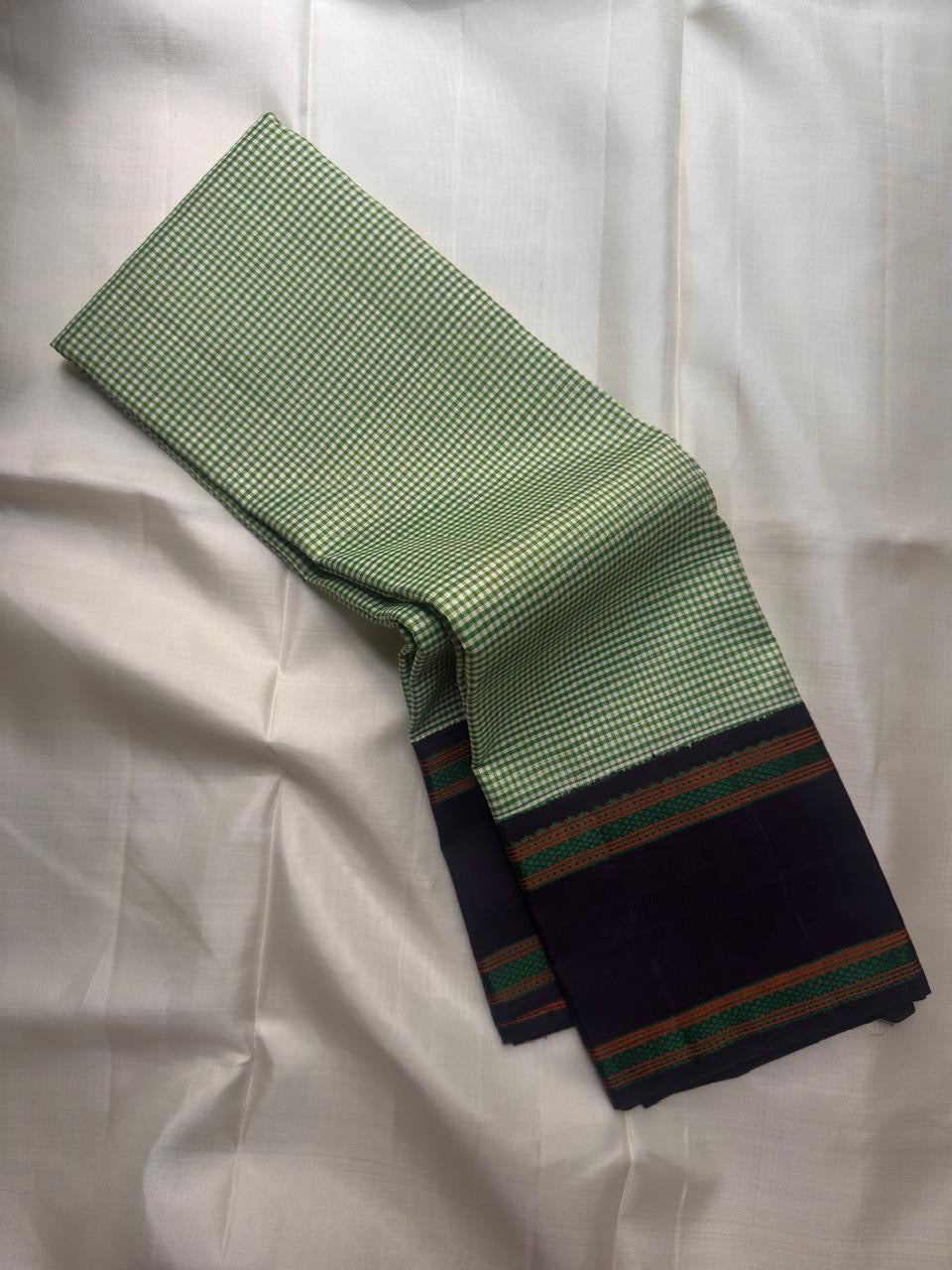 Fresh green handwoven Pure Silk Kanchipuram saree folded to show the deep contrast border