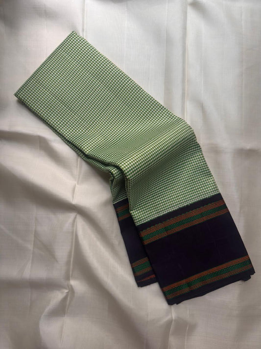 Fresh green handwoven Pure Silk Kanchipuram saree folded to show the deep contrast border