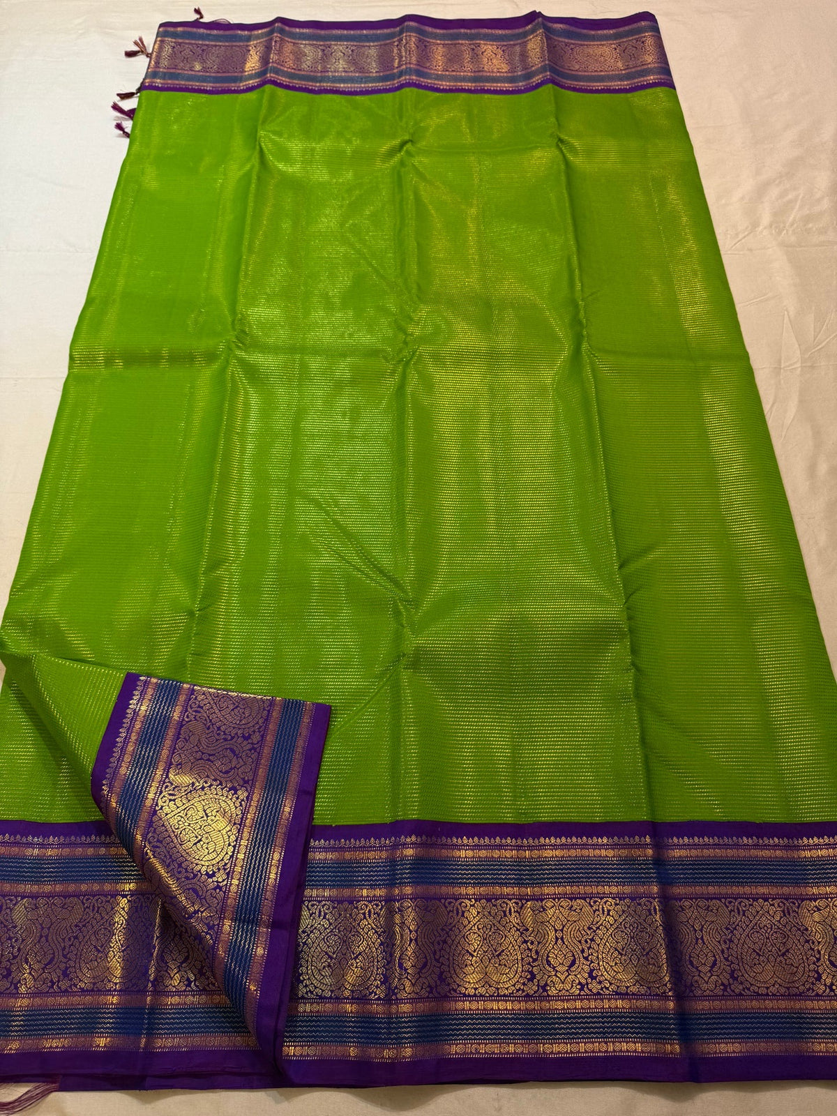 Full view of the Thulir Pachai fresh green Kanjivaram saree with royal violet border