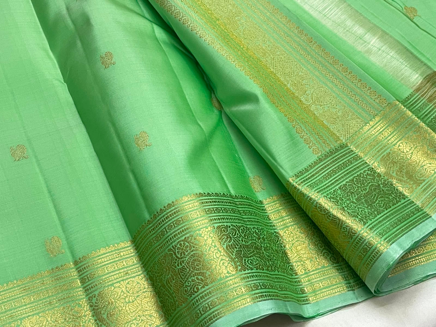 Fresh Pistachio Green Kancheepuram silk saree, gold zari butta motif close-up — Idam Living