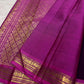 Close view of deep violet pure silk meeting a vivid pink figurative classic-gold zari border.