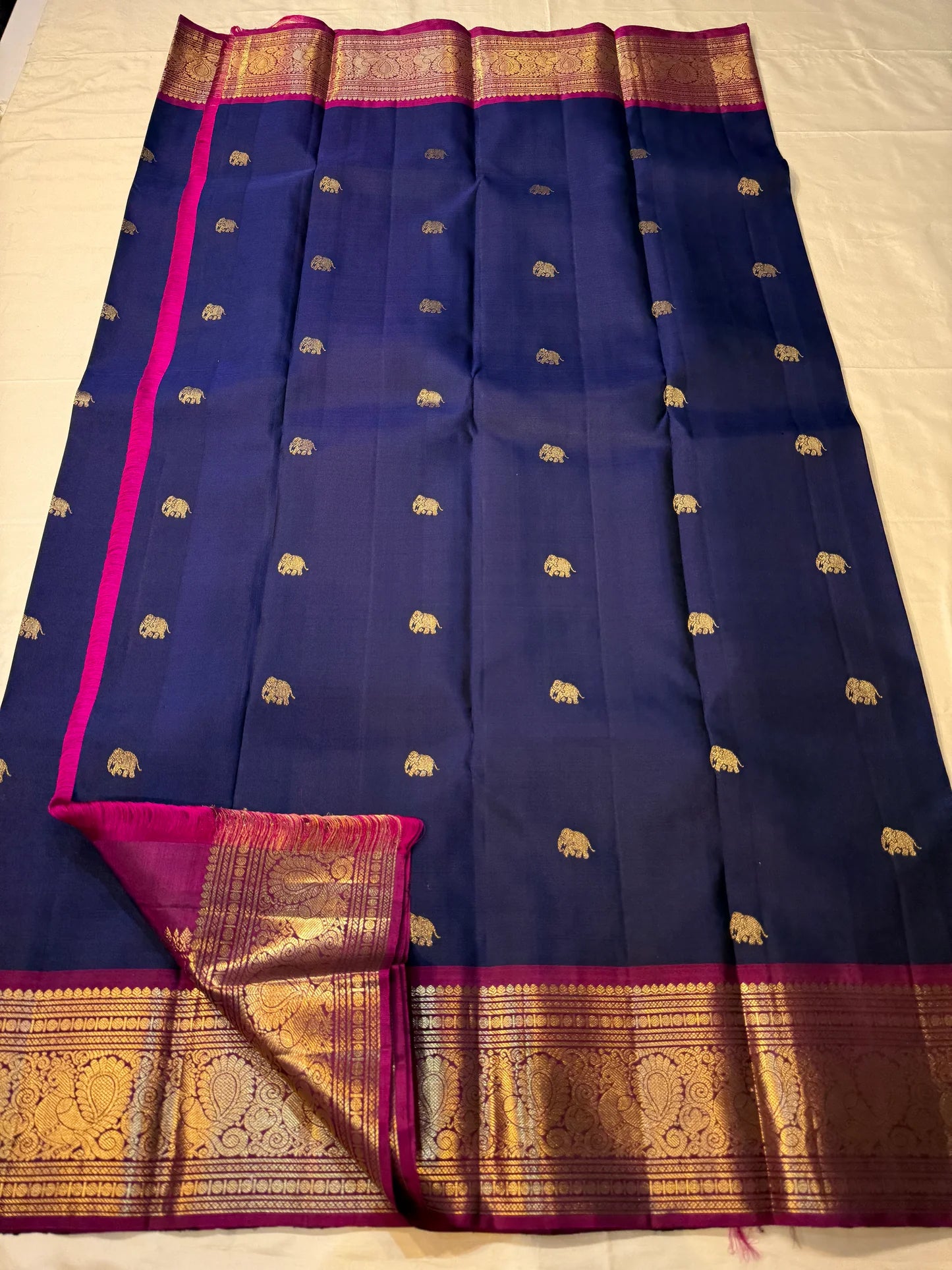 Navy and magenta Pure Kanchipuram silk saree spread showing gold elephant buttas, contrast pallu panel, and zari border, shipped from New Jersey USA.