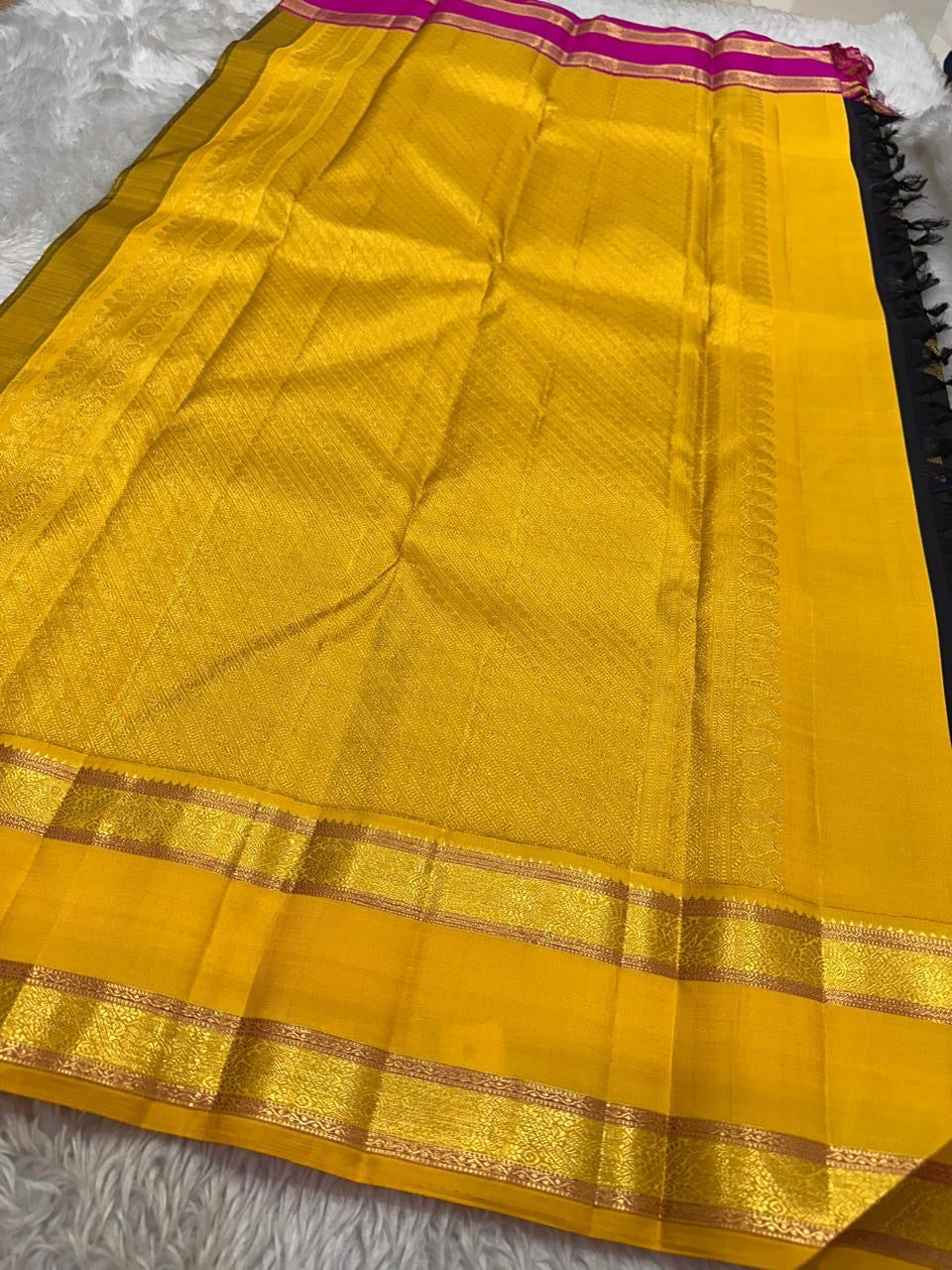 Close view of navy Kanchipuram silk saree featuring antique gold zari motifs and contrast Ganga Jamuna border