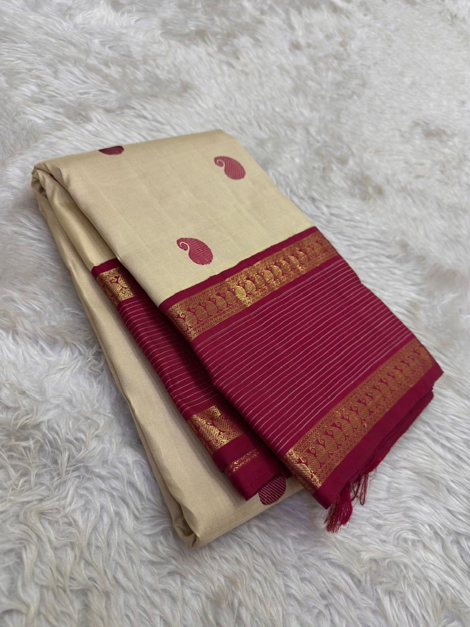 Gold beige KanchiPattu silk body close-up showing maroon silk thread paisley butta motifs