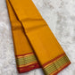 Turmeric Yellow and Rust Orange lightweight Kanchipuram silk saree, olive-green lattice zari border and rust-orange pallu; full layout