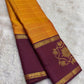 Full view of turmeric gold Kanchipuram saree with floral border and rich layered pallu.