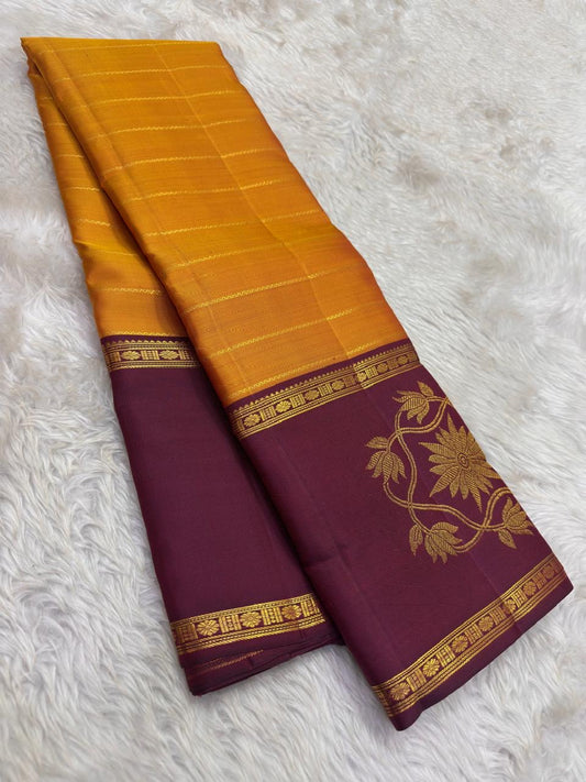 Full view of turmeric gold Kanchipuram saree with floral border and rich layered pallu.