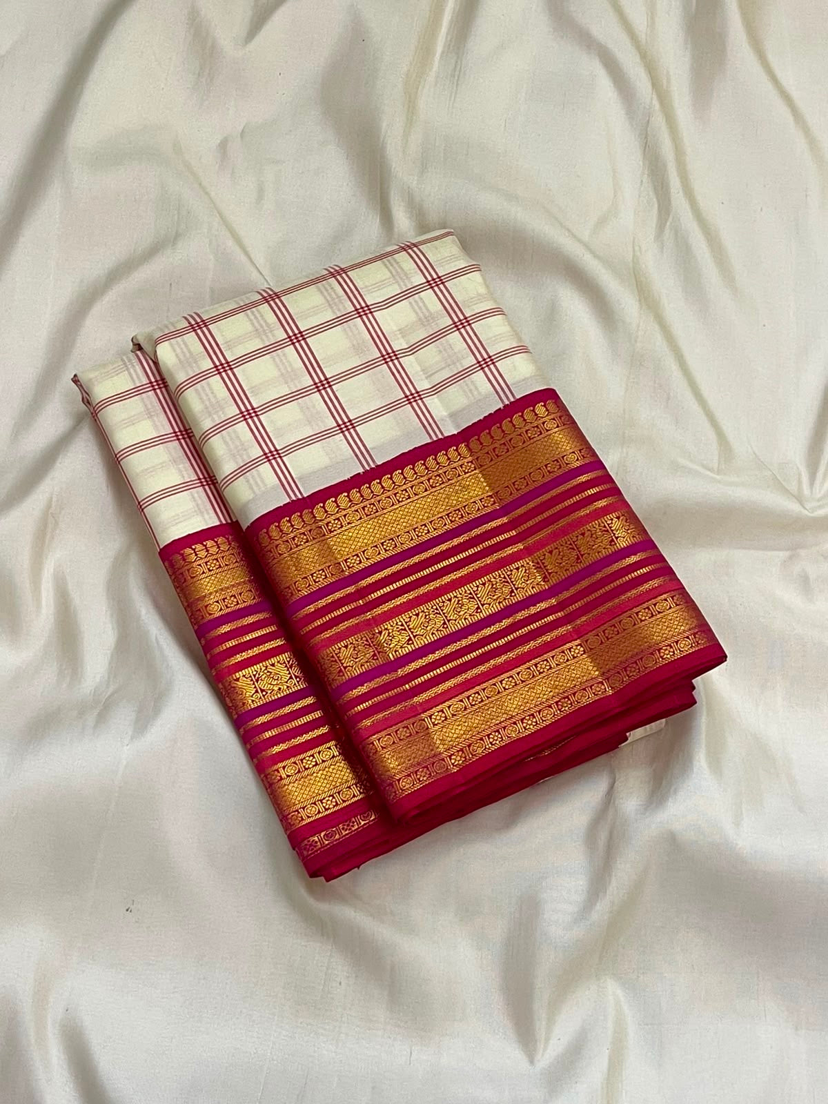 Gold zari border detail on the ivory raspberry pink Kanchipuram saree